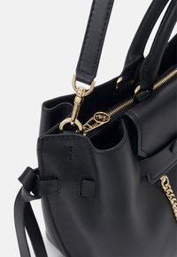 Borsa a mano in pelle nera con zip e hardware dorati, dotata di due manici superiori e una tracolla removibile. Finishing testurizzato, design minimale.
