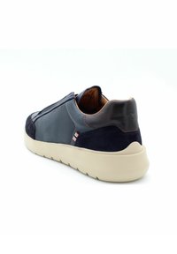 Sneaker in rete e suede blu navy con suola beige, caratterizzata da un tallone in pelle a contrasto e da un accento a righe sul lato.