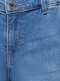 Modré riflové džínsy zblízka zobrazujúce gombík, očko na opasok, predné vrecko a viditeľné detaily šitia.