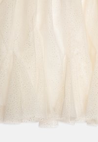 Ivoor tulle stof met zilveren glitters, met een gelaagd ruffleontwerp aan de zoom. Zachte, doorzichtige textuur, lichtgewicht en vloeiend.