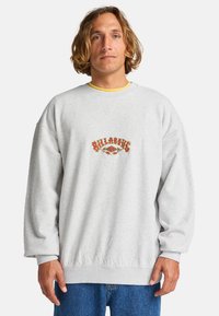 Sudadera gris con cuello redondo, puños de canalé y bajo ribeteado. Presenta un colorido logo "Billabong" bordado en el centro.