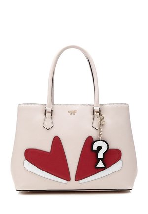 Sac à main beige avec deux poignées, motifs de cœurs rouges et un porte-clés avec un point d'interrogation noir et blanc suspendu à une poignée.