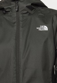 Schwarze Zip-Jacke mit Kapuze, die ein weißes The North Face-Logo auf der Brust trägt.