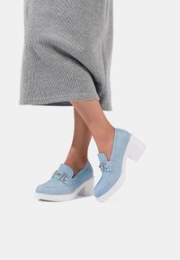 Scarpe con piattaforma in suede azzurro chiaro, con punta quadrata, tacco bianco spesso e dettaglio decorativo con fibbia sul sopra. 