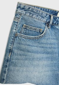 Shorts en denim bleu clair à taille haute, dotés d'une poche arrière, de coutures contrastées et d'un ourlet effiloché. Texture lisse sur l'ensemble.