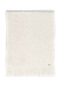 Biały dziergany koc z fakturowanym wzorem warkocza wzdłuż dolnej krawędzi, z małą, dyskretną metką marki w jednym rogu.