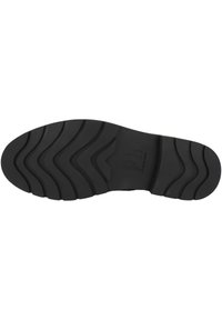 Suela de zapato de goma negra con un patrón de tracción ondulada. Presenta un logotipo de marca en relieve y una textura suave en la superficie.