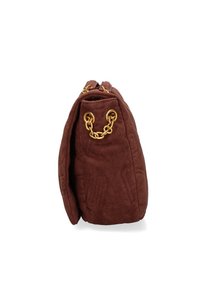 Sac à main en cuir suédé marron avec des poignées en chaîne dorée, vu de côté contre un fond blanc.