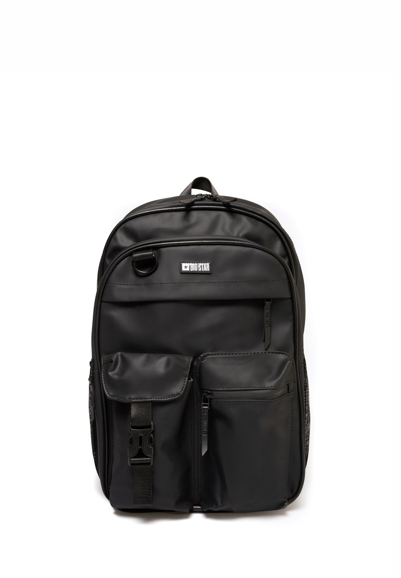 Mochila negra hecha de tela duradera, con varios bolsillos con cremallera, un panel frontal texturizado y un asa de transporte en la parte superior.