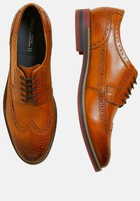 Bruine leren nette schoenen met brogue-details, voorzien van een ronde neus en meerdere veterogen. Een lichte hak zorgt voor stabiliteit.
