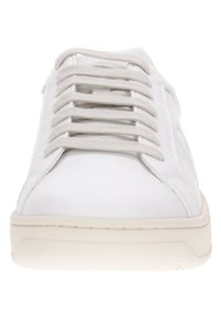 Baskets blanches avec une tige en cuir lisse, lacets gris, bout arrondi et semelle texturée pour une meilleure traction. Design minimaliste, sans logos visibles.