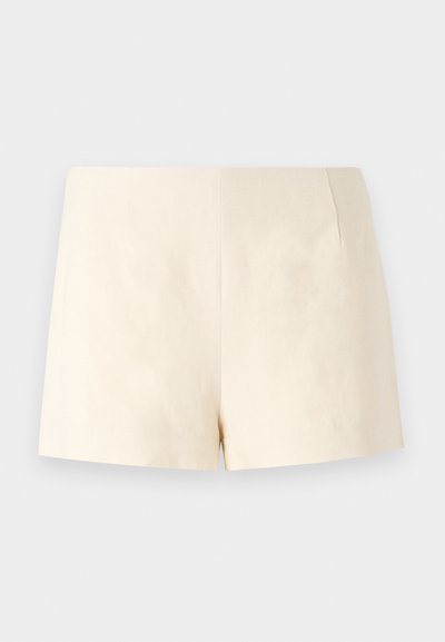 Bēšas piegriezuma šorti, kas izgatavoti no viegla auduma, ar gludu tekstūru, skaidrām līnijām un bez redzamām aizdares sistēmām vai kabatām.