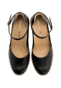 Scarpe in pelle nera con punta aperta e cinturino alla caviglia, dotate di una soletta imbottita e un motivo a pois. Finitura beige lungo la suola.