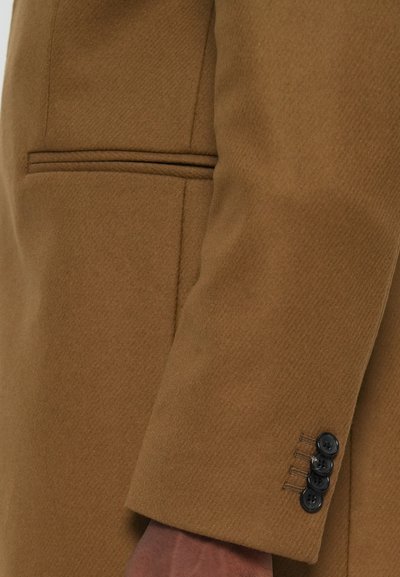 Caban din lână maro cu un finisaj texturat, design slim-fit și patru butoane negre pe manșetă, având un aspect curat și ajustat.