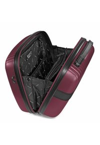 Hard-shell suitcase in burgundy with a textured finish. Interior features black fabric compartments with branding and zippered pockets.