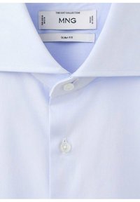 Svetlo modra srajca z ožjim krojem in klasičnim ovratnikom, z zapiranjem na gumbe iz belega plastike in gladkim, rahlo teksturiranim tkanjem.