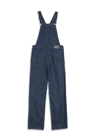 Salopette en denim bleu foncé avec petits motifs floraux rouges et verts, jambes larges, deux poches arrière et bretelles réglables.