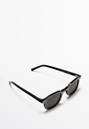 Lunettes de soleil noires avec verres teintés. Design à monture carrée, finition brillante. Présente des accents en métal et une légère courbe sur les branches. Marqué CE.