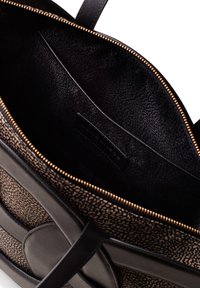 Zwarte lederen tote bag met een getextureerde bruine interieur. Beschikt over een gouden rits en gladde accenten, en heeft een ruime hoofdcompartiment.