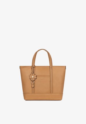 Torba typu tote z brązowej skóry z podwójnymi uchwytami i przednią kieszenią, ozdobiona skórzaną zawieszką w kształcie kwiatu z metalowym guzikiem na środku.