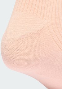 Svijetlo ružičasta ankletska čarapa s rebrastom teksturom i glatkim završetkom, koja ima ojačani petu i prste za dugotrajnost.