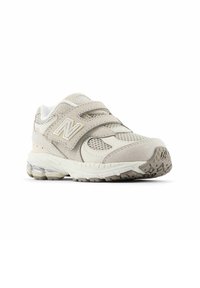 Light gray athletic shoe featuring suede and mesh materials, dual velcro straps, textured outsole, and a visible air cushioning unit.