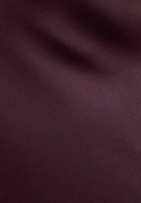 Burgundowa tkanina o gładkiej, matowej fakturze; lekko pofałdowana powierzchnia sugerująca miękkość i płynność materiału.