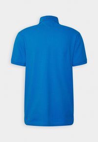 Blå polo med krage och korta ärmar, tillverkad av mjukt tyg med en jämn textur, med en enkel design utan mönster.