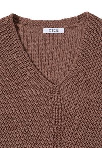 Pull en tricot marron à col en V avec texture côtelée et une étiquette blanche indiquant "CECIL" au niveau de l'encolure.