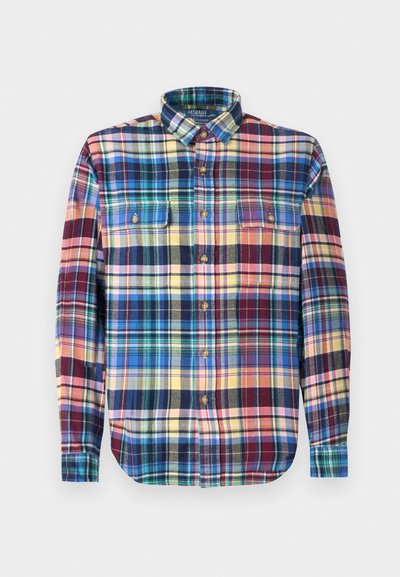 Camisa xadrez em tecido multicolorido com colarinho abotoado, dois bolsos no peito e uma bainha arredondada. Os botões são castanhos.