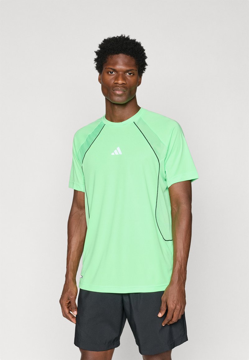 Light green athletic shirt with short sleeves, contrast black accents along the seams, and a small white logo on the chest.