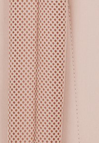 Tessuto pesca con una texture liscia a sinistra e un materiale a rete con piccoli fori tondeggianti a destra, che migliora il flusso d'aria.