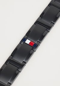 Musthave mustraha mustri silmatud kellarihm, millel on rombikujulised lingid, millel on keskne rõhk punase, valge ja sinise värviga. Sujuv tekstuur, stiilne disain.