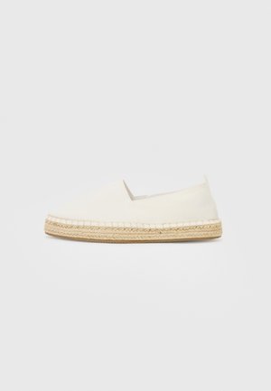 Espadrille blanche à enfiler avec semelle en jute tressé et design minimaliste sur fond neutre.