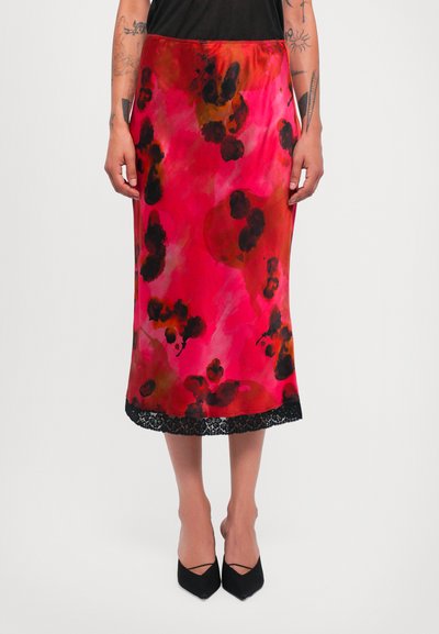 Satin-Midi-Rock in lebhaftem Pink mit schwarzen Blumenmustern und schwarzem Spitzenbesatz; gerade geschnitten, glatte Textur, kombiniert mit spitzen schwarzen High Heels.