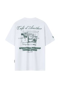 Biele tričko so zelenou technickou kresbou espresso stroja a textom "Café d'Another" a "Medzinárodné priateľstvo cez espresso."