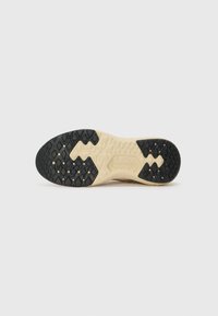 Sko med såle i sportstil med teksturert design, som har en svart gummibase og en lysfarget mellomsåle. Mønstrene inkluderer diamantformer og sekskanter.