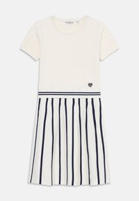 Sukienka dzianinowa w kolorze kremowym, z krótkimi rękawami, teksturowanym górnym partem, spódnicą w paski w kolorze granatowo-białym oraz małym logo w kształcie serca na talii.