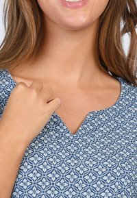 Blau gemustertes Kleid mit V-Ausschnitt, aus leichtem Stoff, mit blumenartigen Motiven in hellerem Blau auf einem dunkler blauen Hintergrund.