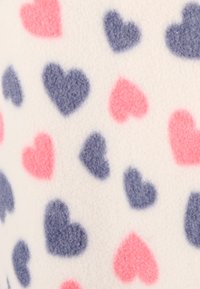 Fleece stof met een patroon van roze en marineblauwe harten op een witte achtergrond. Zachte textuur met gelijkmatig verdeelde hartontwerpen.
