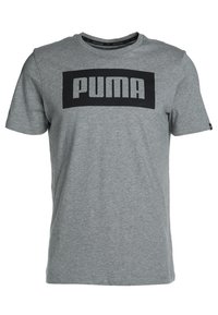 Harmaa puuvillapaita, jossa on musta suorakulmainen printti, jossa lukee "PUMA" lihavoinnilla valkoisilla kirjaimilla. Paidassa on lyhyet hihat ja pyöreä kaula-aukko.