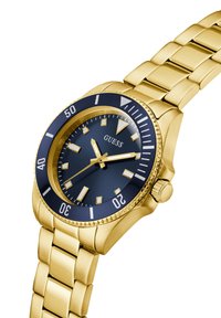 Gouden metalen horloge met een blauwe wijzerplaat, luminescente markeringen en een unidirectionele bezel. Het schakelarmbandontwerp versterkt zowel de sterk als de stijl.