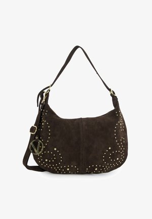 Mørkebrun skuldertaske i ruskind med guldfarvede nitter og et gyldent rundt vedhæng, med justerbar rem og halvmåneform.