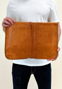 Bruine leren portfolio met een gladde, gestructureerde oppervlakte, met een eenvoudig ontwerp en een striksluiting in het midden.