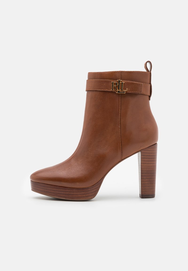 Bruine leren enkelboot met een stevige hak, gouden RL-logoaccent op de band, ronde neus en een getextureerd houten platform.