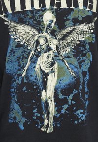 Czarna koszulka z niebiesko-białą grafiką przedstawiającą skrzydlatą, szkieletową postać z misternymi detalami i postarzaną, tła wzorem.