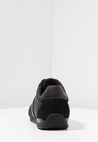 Czarny sneaker wykonany z gładkiej skóry i teksturowanej zamszu. Posiada wzmocnioną piętę, kontrastujące paski i gumową podeszwę.