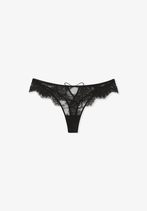 Zwarte kanten string met bloemmotief, gegolfde randen en een centrale strikdetails. Heeft een doorschijnende textuur en smalle zijbandjes.