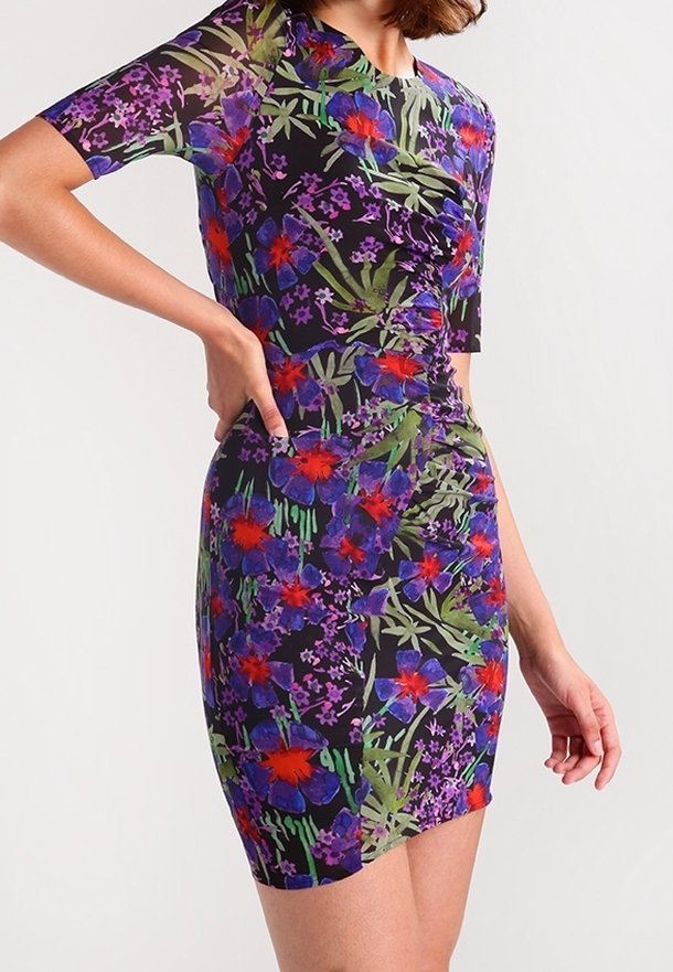 Vestido ajustado de manga corta con fondo negro y un vibrante patrón floral en rojo, púrpura y verde; presenta un detalle fruncido en el lado.