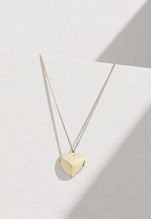 Collier avec pendentif en forme de cœur en or sur une chaîne fine, surface polie, texture lisse, avec des reflets subtils sur un fond clair.